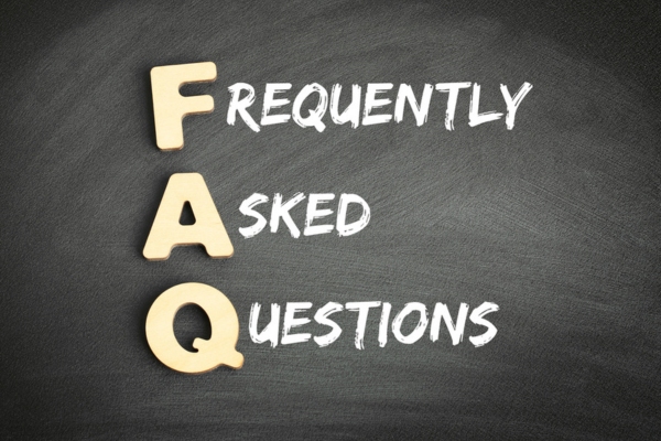 Frequently Asked Questions with FAQ spelled using wooden letters and words written using chalk