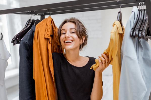 woman smiling while choosing clothes to wear