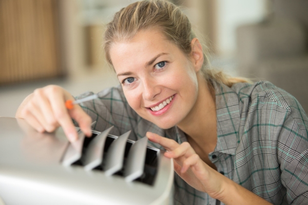 woman examining portable air conditioner