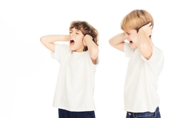 young boys covering ears due to loud noise coming from portable air conditioner