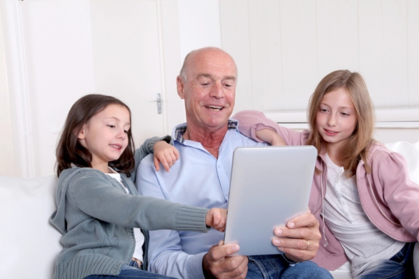 grandfather hanging out with granddaughters while staying warm depicting reliability of heating oil system