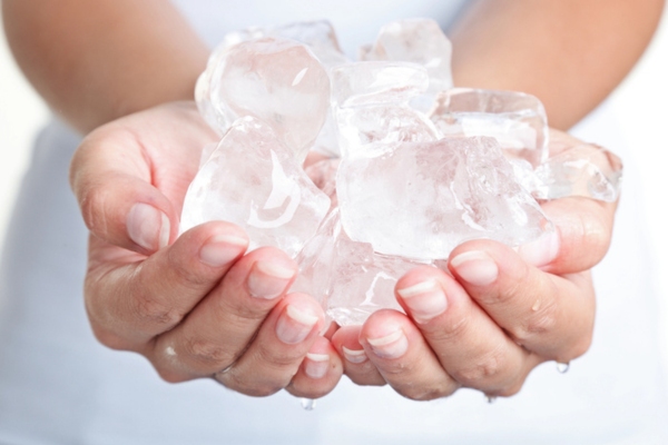 woman's hands holding a bunch of ice depicting heating oil freezing point