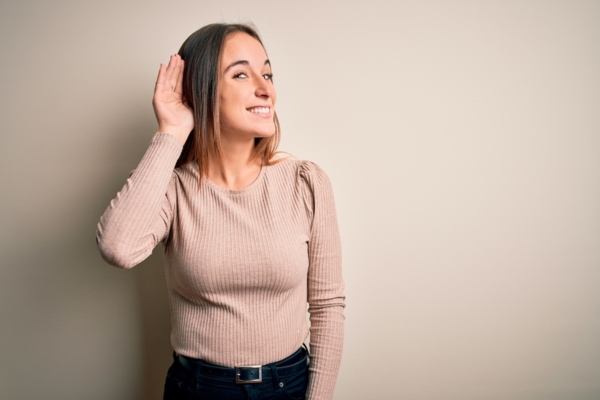 woman cupping her right ear depicting listening to furnace sounds