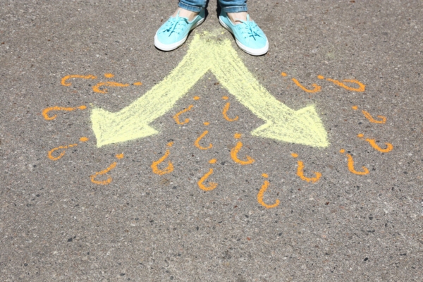 Female feet making choice on asphalt with drawing arrows depicting oil delivery option